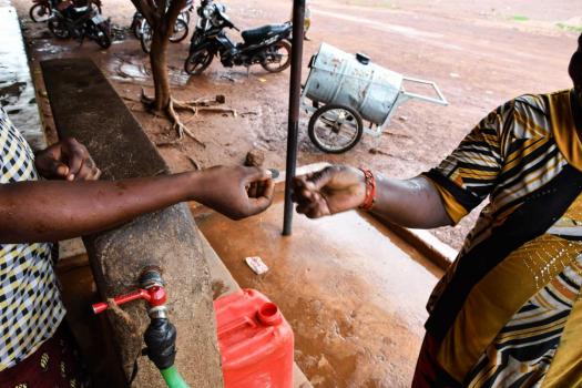 Burkina Faso, Women exchanging money at the water pump