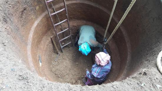 Women digging an open well in India