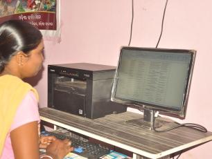Woman sitting in front of computer screen in Ganjam district, Odisha, India