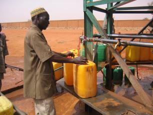 Man filling jerry cans with water in Niger