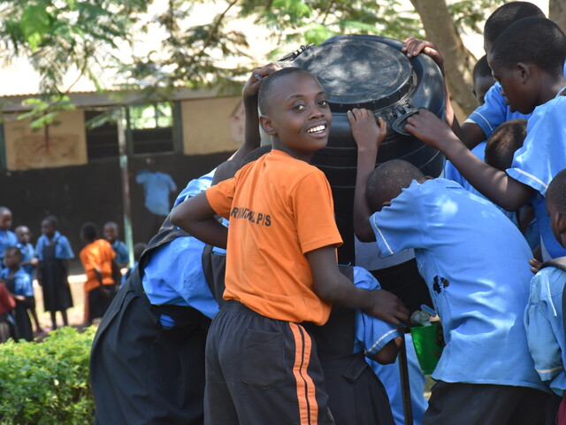 School pupils at Rwankenzi wash their food containers after the lunch break 