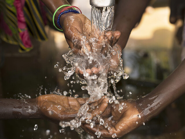  Stream of water pouring into children’s hands in southern Burkina Faso. Photo: Jadwiga Figula / Getty Images. Stream of water 